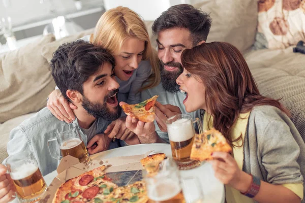 Улыбающиеся Друзья Едят Пиццу Пьют Пиво Дома — стоковое фото