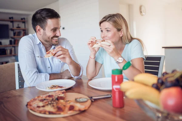 Młoda Uśmiechając Się Para Jeść Pizzę Domowej Roboty Kuchni — Zdjęcie stockowe