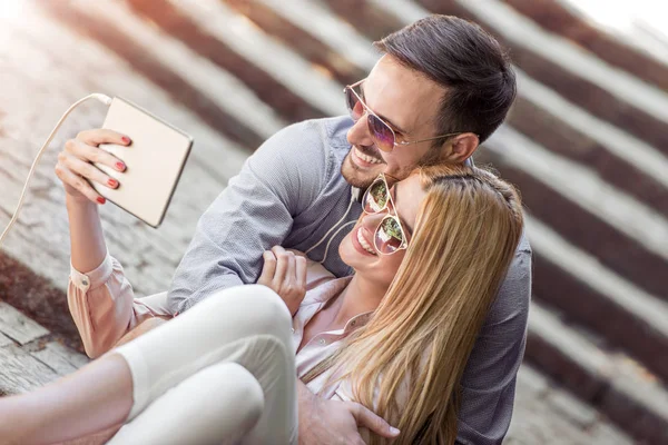Glückliches Junges Paar Sitzt Zusammen Freien Und Schaut Auf Tablet — Stockfoto
