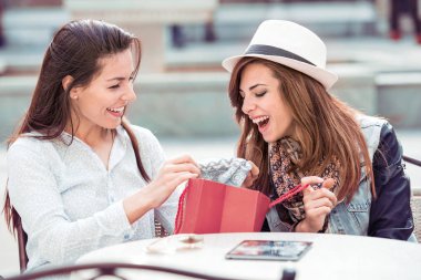 Şehrin alışveriş torbaları ile mutlu genç kadınlar. Satılık, tüketim ve insanlar kavramı.
