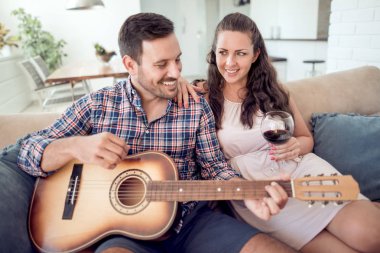 Yakışıklı adam biraz müzik gitar onun kız arkadaşı oynamak..