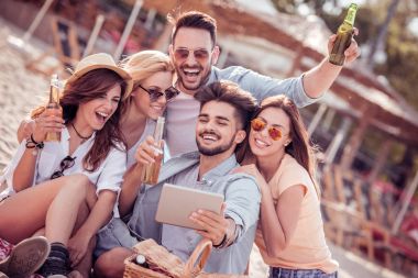 Selfie akıllı telefon ile birlikte sahilde alarak neşeli arkadaş grubu.