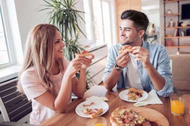 Çift evde pizza yemek. İnsanlar, gıda, sevgi ve mutluluk kavramı.