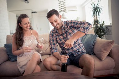 Oturma odasında kanepede otururken şarap içme Çift.