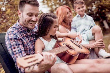 Kaliteli zaman zevk, gitar kendi bahçesinde oynayan genç aile.