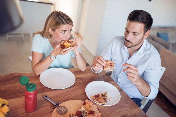 Молодая Улыбающаяся Пара Ест Домашнюю Пиццу Вместе Кухне — стоковое фото