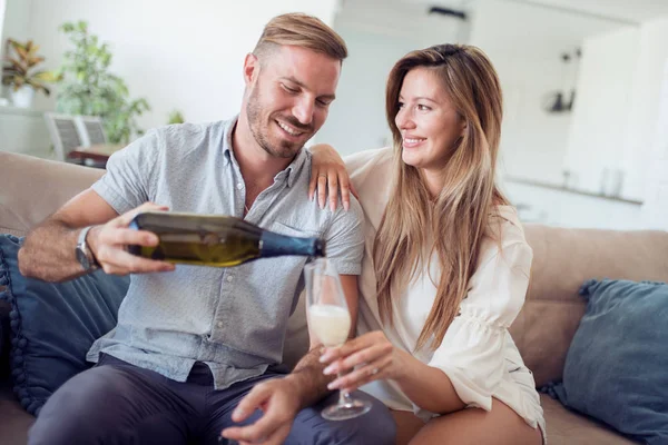 Hermosa pareja de adultos sentados en el sofá y bebiendo vino . — Foto de Stock