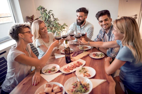 Friends meeting.Group of happy people have friendly conversation,say cheers, laughing at party dinner