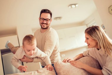 Genç aile mutlu küçük oğlu ile evde oynarken.
