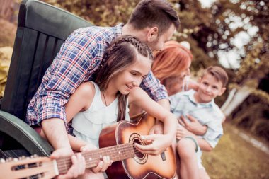 Kaliteli zaman zevk, gitar kendi bahçesinde oynayan genç aile.