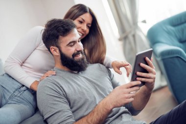 Genç çift evde rahatlatıcı ve film izlerken.