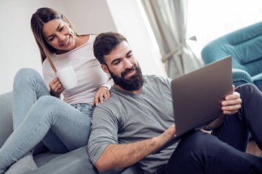 Genç çift evde rahatlatıcı ve film izlerken.