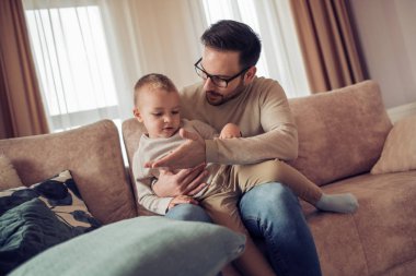 Mutlu baba oğluyla evde yatakta oynamak. Aile, aşk, eğlenceli ve mutluluk kavramı.