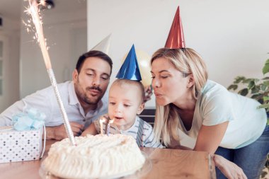 Doğum günü pastası partide mum dışarı Birthday.Little çocuk darbeler. Bir çocuk mutlu aile kutluyor doğum günü.
