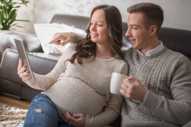 Evde tablet kullanma çift, genç bir kadın hamile olduğunu.