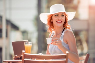 Dizüstü bilgisayar kullanarak iş kadını kafede e-postayı denetleme. 