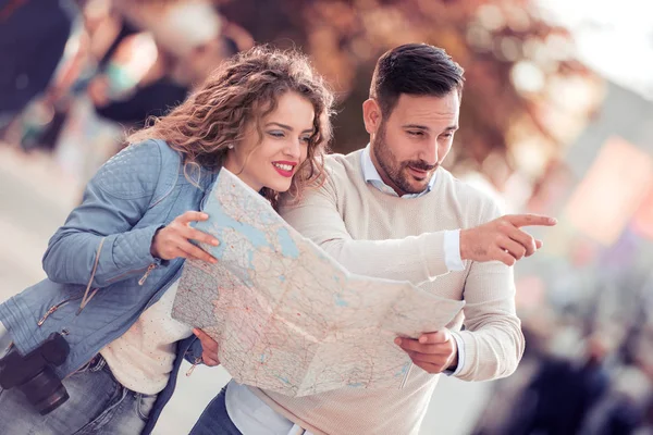 Traveling couple searching for their next destination with a map.