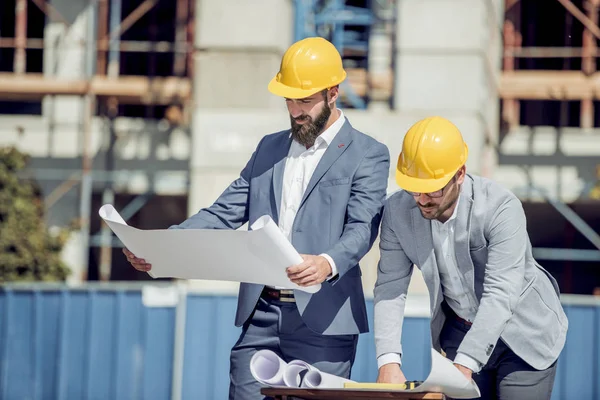 İnşaat alanında iki inşaat işçisi.