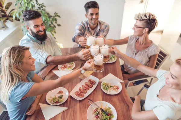 Friends meeting. Group of happy people have friendly conversation,say cheers, laughing at party dinner at home