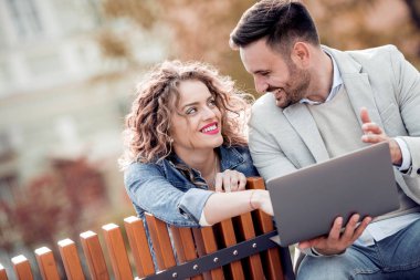 Çift bankta oturan ve bir şey bir laptop arıyorum.