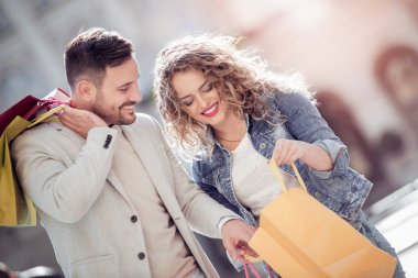 Mutlu çift alışveriş torbaları ile portresi. Satılık, tüketim ve insanlar kavramı.