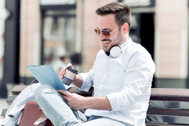 Gitmek için dinlenme, açık havada kahve ile zevk genç adam gülümseyen