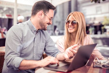 Mutlu çift birlikte kahve dükkanında vakit, dizüstü bilgisayar kullanarak.