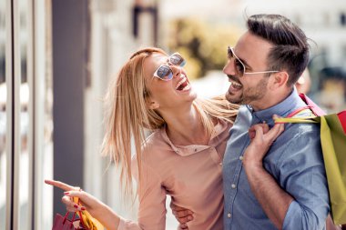 Şehirde alışveriş yaparken onlar alışveriş torbaları tutan şık genç Çift.