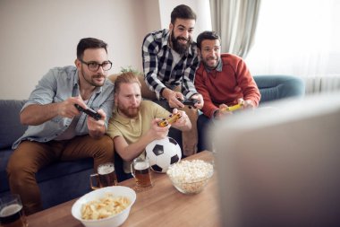 Video oyunları oynarken arkadaş grubu. Oturma odasında ve birlikte oynayan gençler.