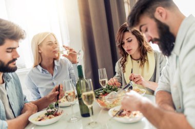 Arkadaşlar evde yemek yiyor. Grup gözlük, mutlu insan konuşmak ve evde sağlıklı yemek yeme.