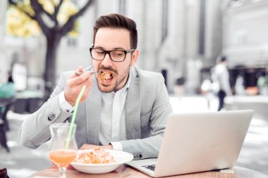 Öğle yemeği molası işadamı kafe, taze makarna yiyor.