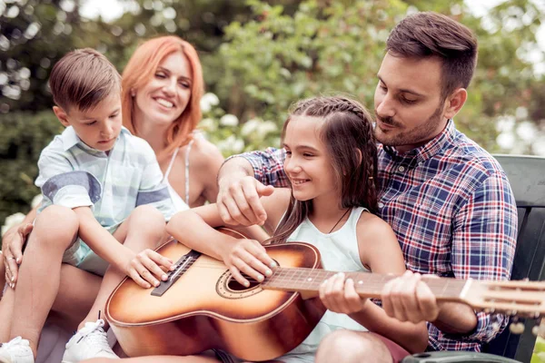 Kaliteli zaman zevk, gitar kendi bahçesinde oynayan genç aile.