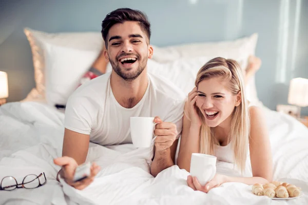 Hombre y mujer desayunando en la cama . — Foto de Stock