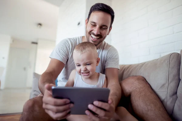 Feliz Padre Hijo Sentados Sofá Viendo Algo Dispositivo Tableta — Foto de Stock