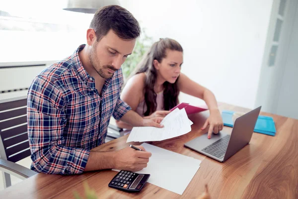 A fiatal pár a családi pénzügyi papírokat nézi. — Stock Fotó