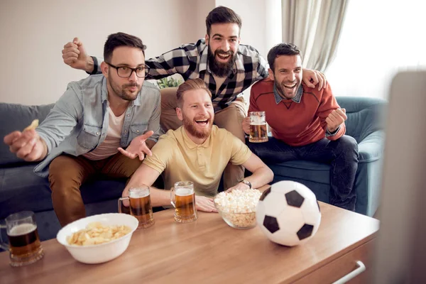 Friendship,sports and entertainment concept-happy male friends supporting football team at home.
