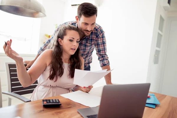 Pareja en casa pagando facturas con laptop — Foto de Stock