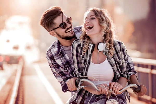 Jovem casal amoroso namoro enquanto andar de bicicleta — Fotografia de Stock