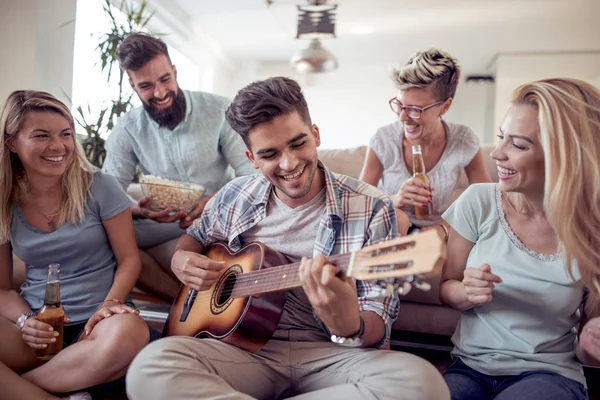 Grupo Amigos Divirtiéndose Sala Estar Jóvenes Felices Tocando Guitarra Cantando — Foto de Stock