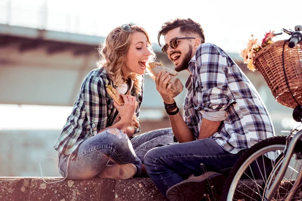 Pareja comiendo sándwiches al aire libre — Foto de Stock