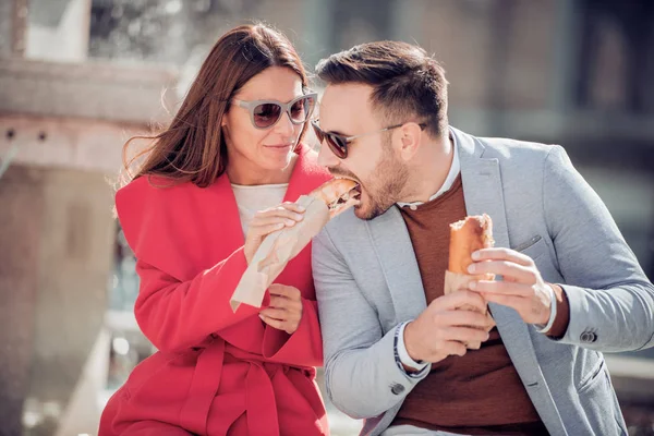 Pareja comiendo sándwiches en la ciudad — Foto de Stock