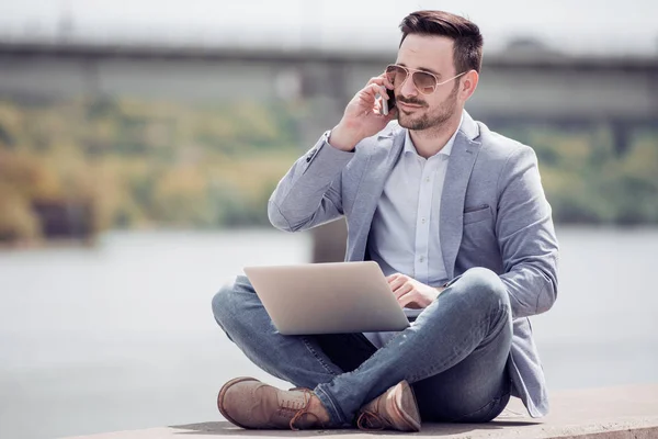 Homem Atraente Sentado Lado Fora Concreto Usando Telefone Celular Laptop — Fotografia de Stock