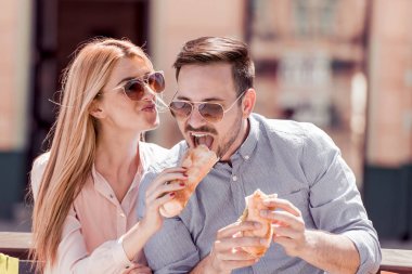 Eğleniyor şehirde, kahvaltı keyfi mutlu sevgi dolu çift. Onlar gülüyor ve sandviç yeme ve having a büyük zaman.