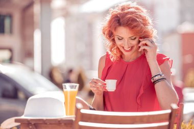 Meşgul kadın kahve dükkanında istimal hareket eden telefon