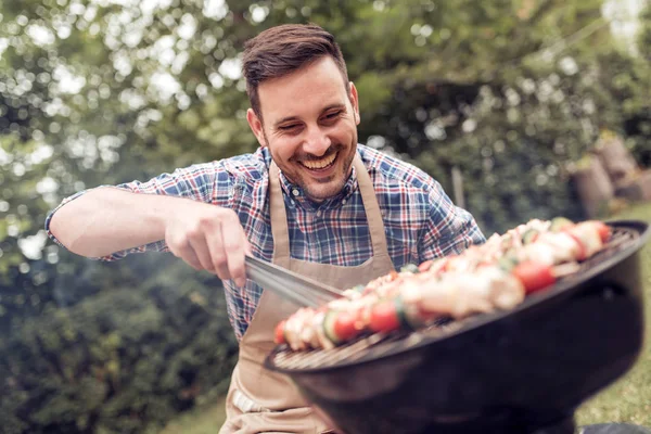 Man cooking meat on barbecue