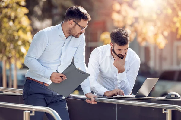 Dois Empresários Bonitos Estão Usando Laptop Sorrindo Enquanto Estão Livre — Fotografia de Stock