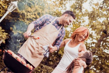 Mutlu genç aile öğle yemeği Barbekü bahçede güneşli günde partisi.