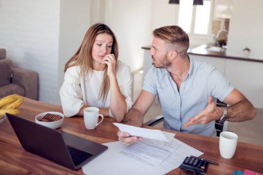 Hesapları ile laptop oturma odasında yapıyor endişeli genç Çift