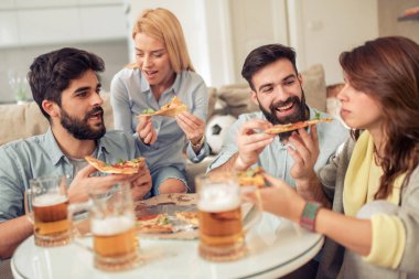 Pizza yiyip evde bira içmeyi gülümseyen arkadaşlar