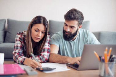 Genç karı koca laptop evrak ile çalışma